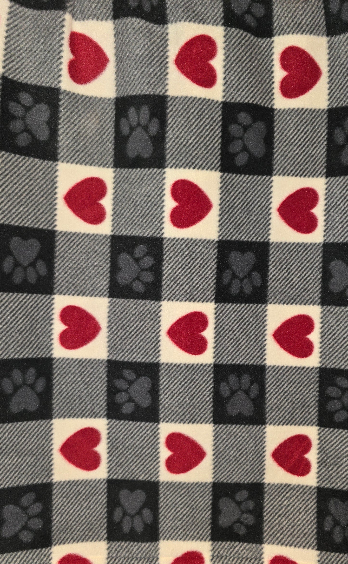 Black, gray and white plaid fleece dog blanket with red hearts.