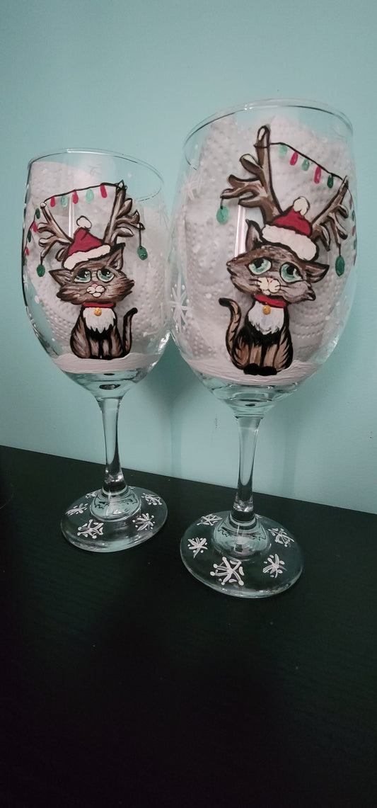 Christmas kittens painted on stemmed wine glasses.